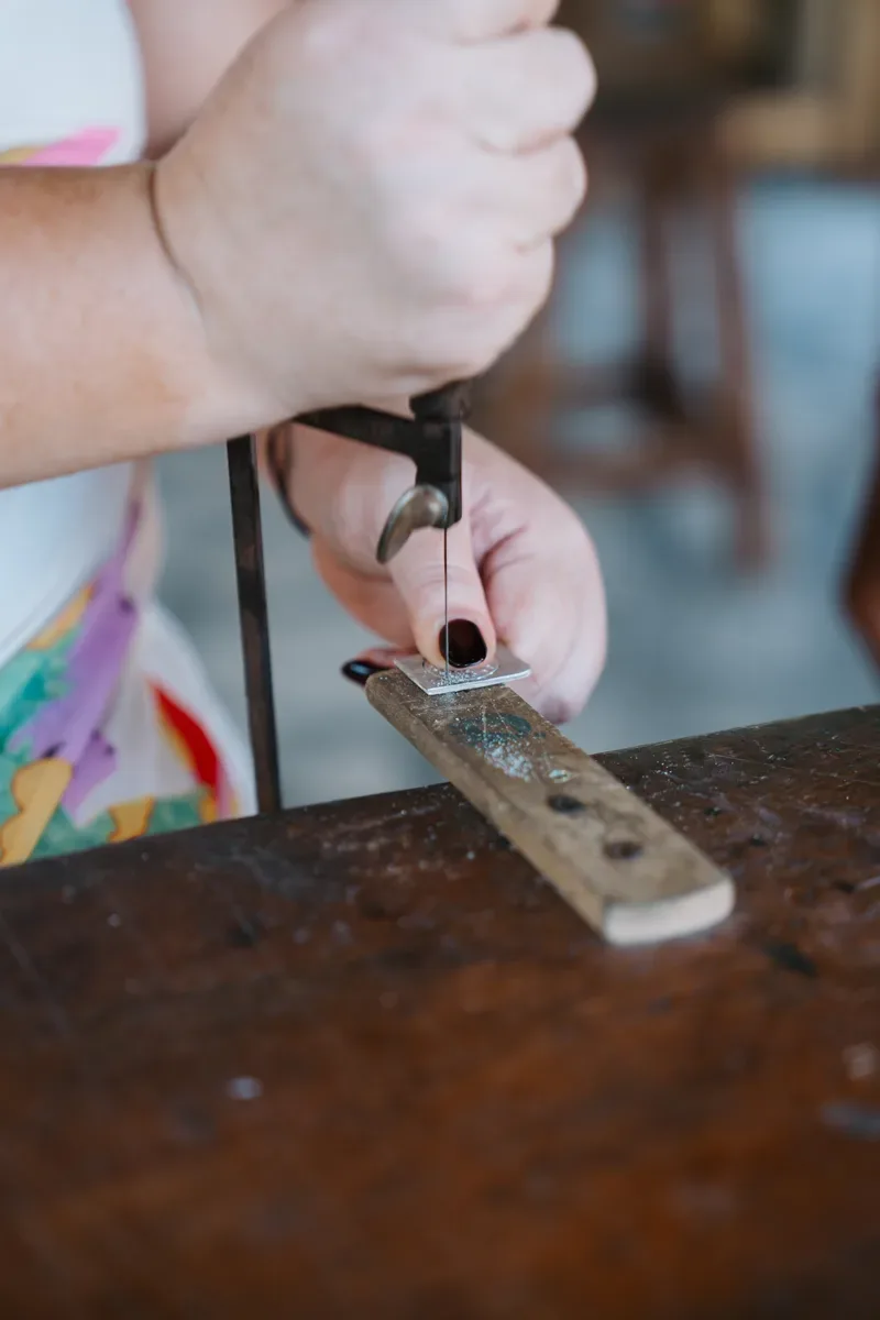 Stamping letters into a silver band with a hammer
