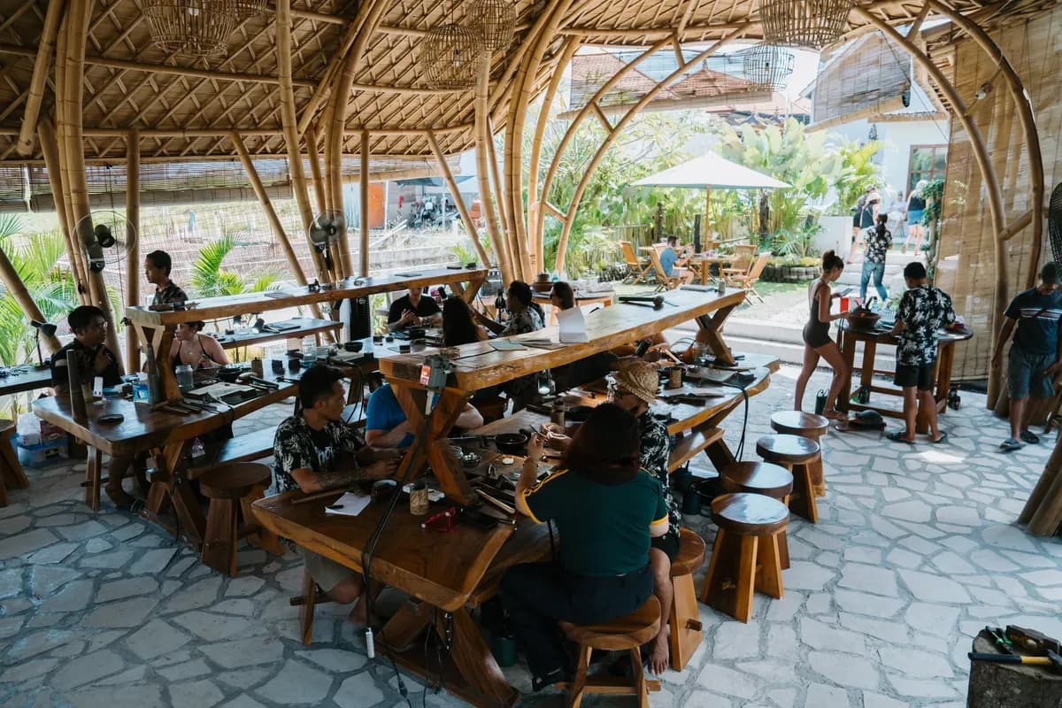 Guests around the long benches of the open-air workshop during a group class